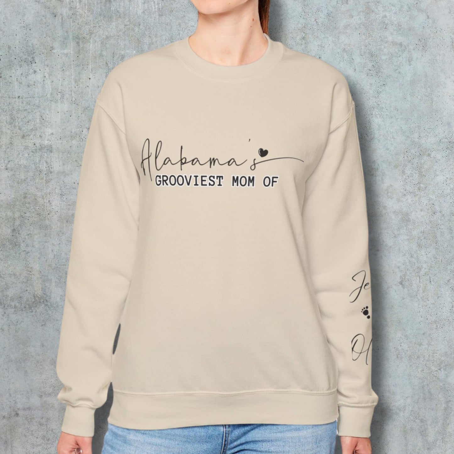 Woman modeling Alabama's Custom Mom Crewneck Gildan Sweatshirt, posing against a wall, highlighting the fit and design.
