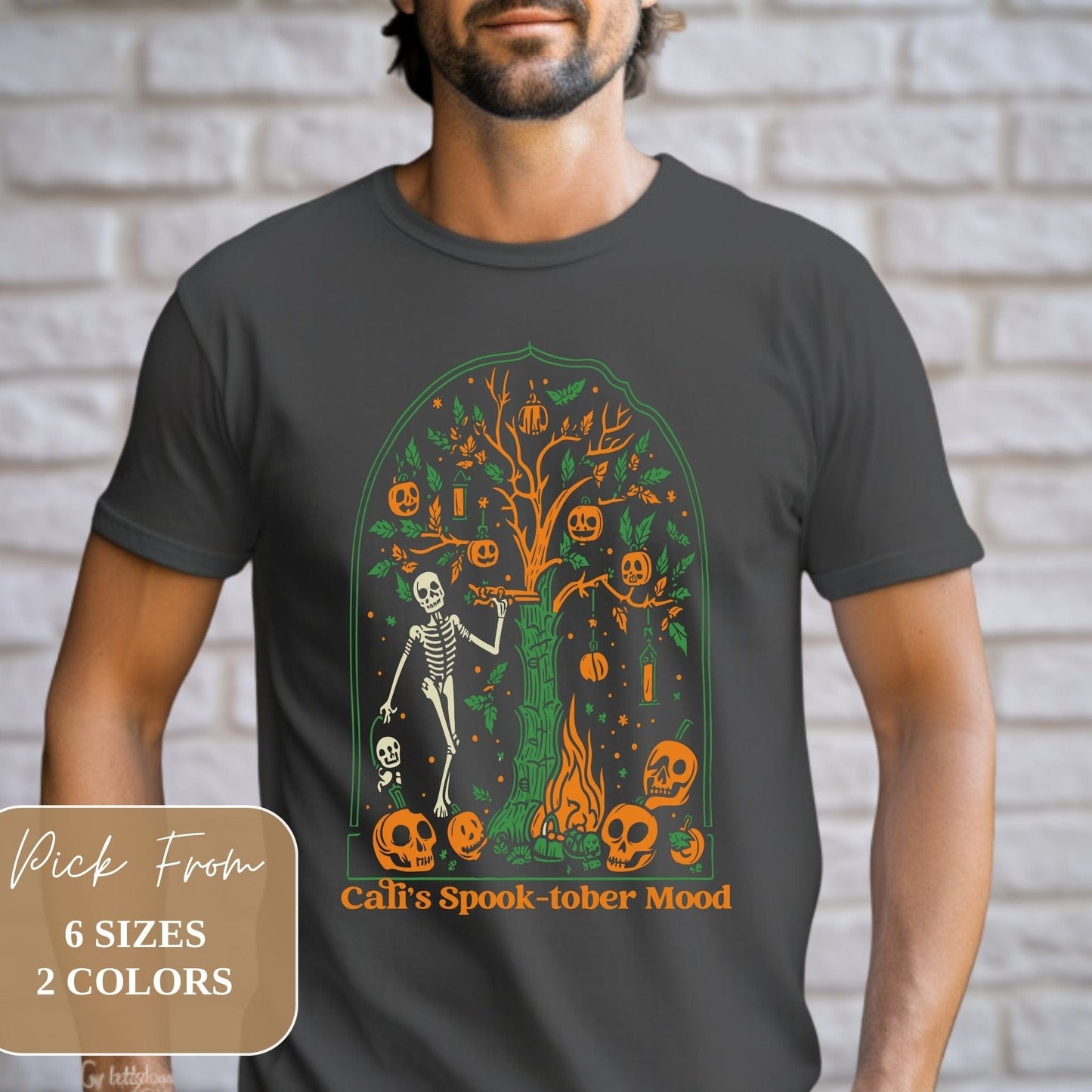 Male model showcasing Trendy California Halloweentown 2023 Skeleton Printed Halloween Dark Grey Gildan G6400 Shirt
