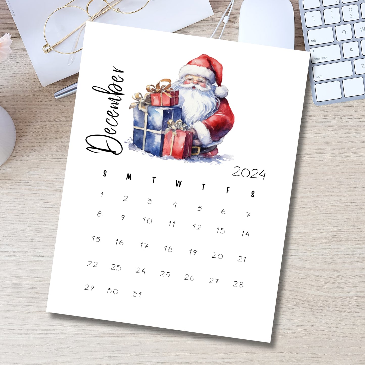 December 2024 A4 calendar with Santa and gift boxes illustration displayed in modern workspace setting with keyboard, glasses and pen, perfect for teacher planning