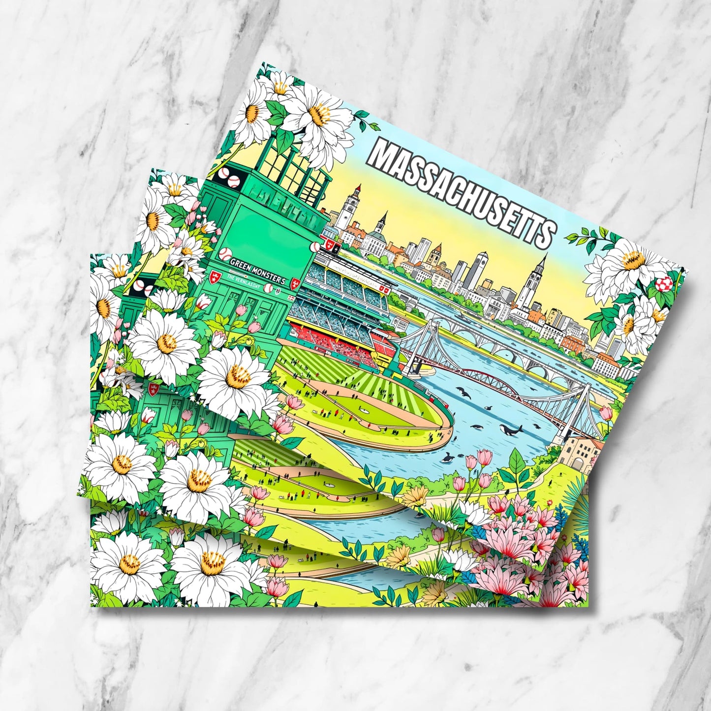 Stack of Massachusetts prints featuring Fenway Park's Green Monster, Boston skyline, river with whales and daisy floral border on marble.