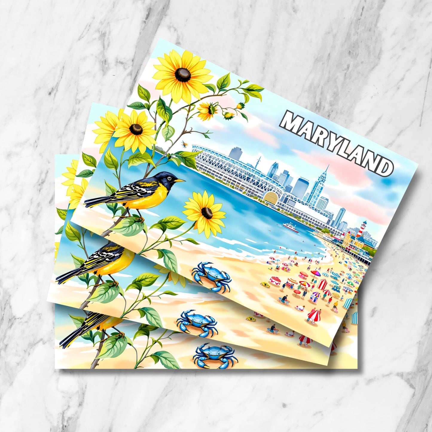 Stack of Maryland watercolor prints featuring Baltimore skyline, blue crabs, Baltimore Oriole, and Black-Eyed Susan flowers on marble background.