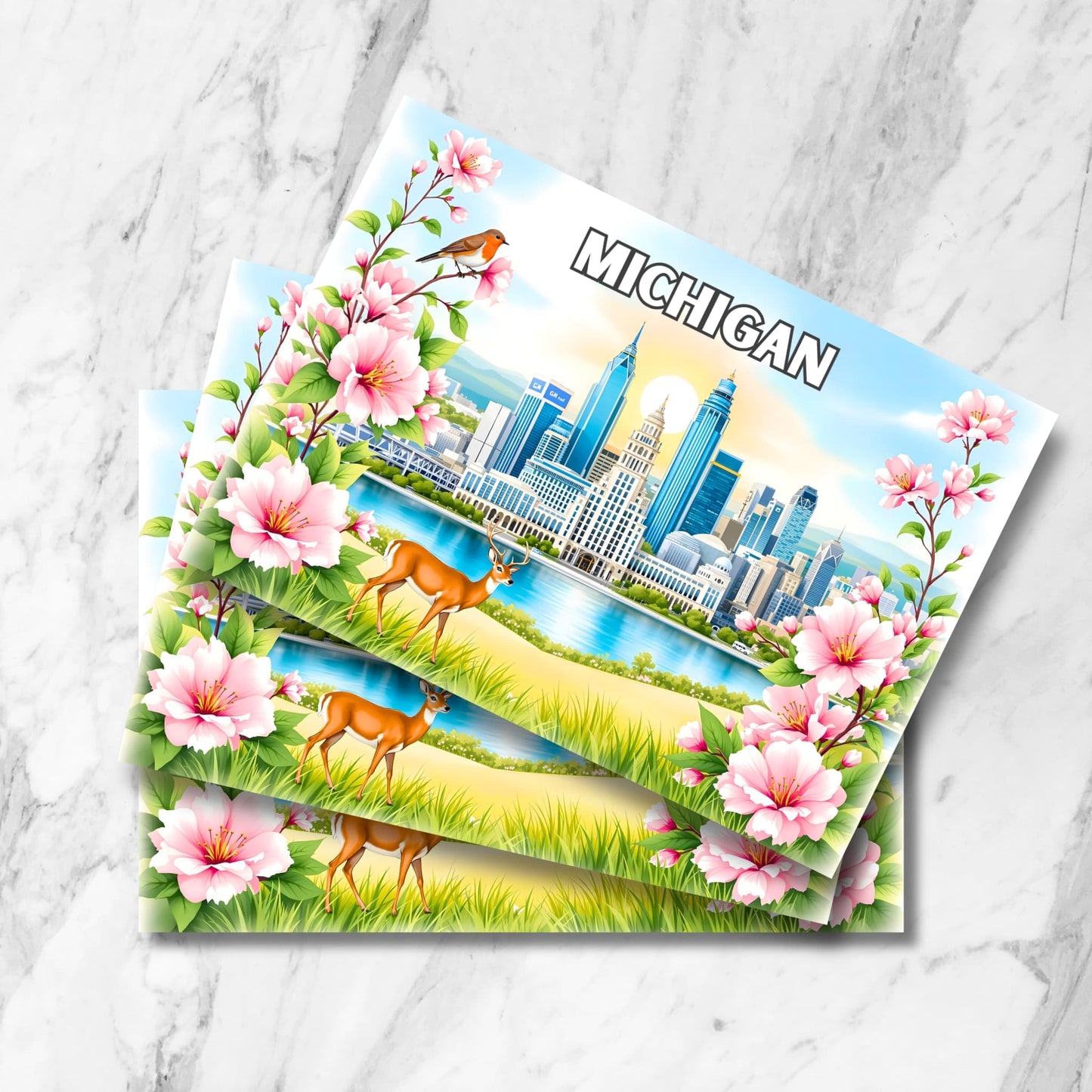Stack of Michigan postcards featuring Detroit skyline, apple blossoms, robin and deer with waterfront view on marble background.