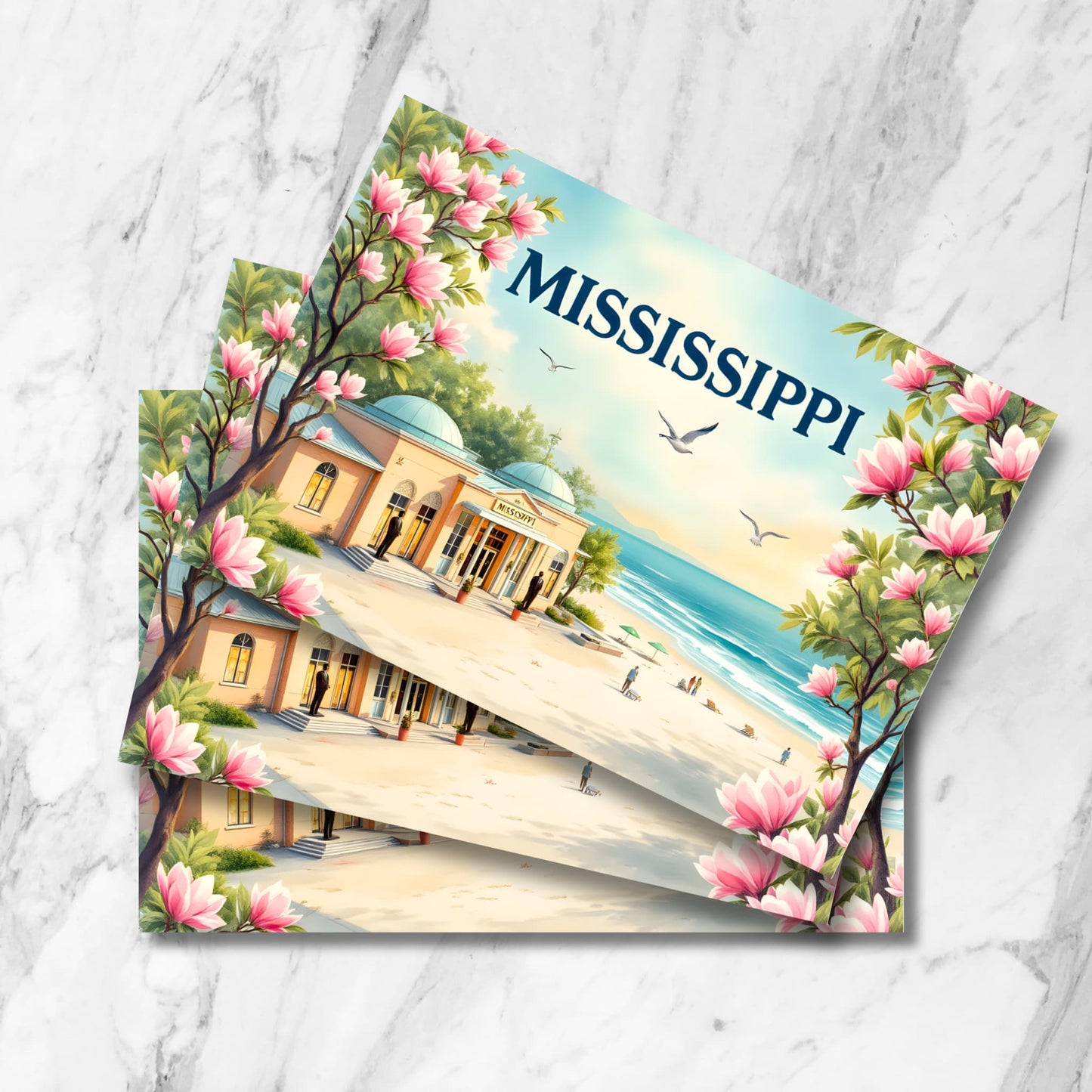 Stack of Mississippi postcards featuring coastal pavilion, beach scene, magnolia blossoms and seagulls on marble background.