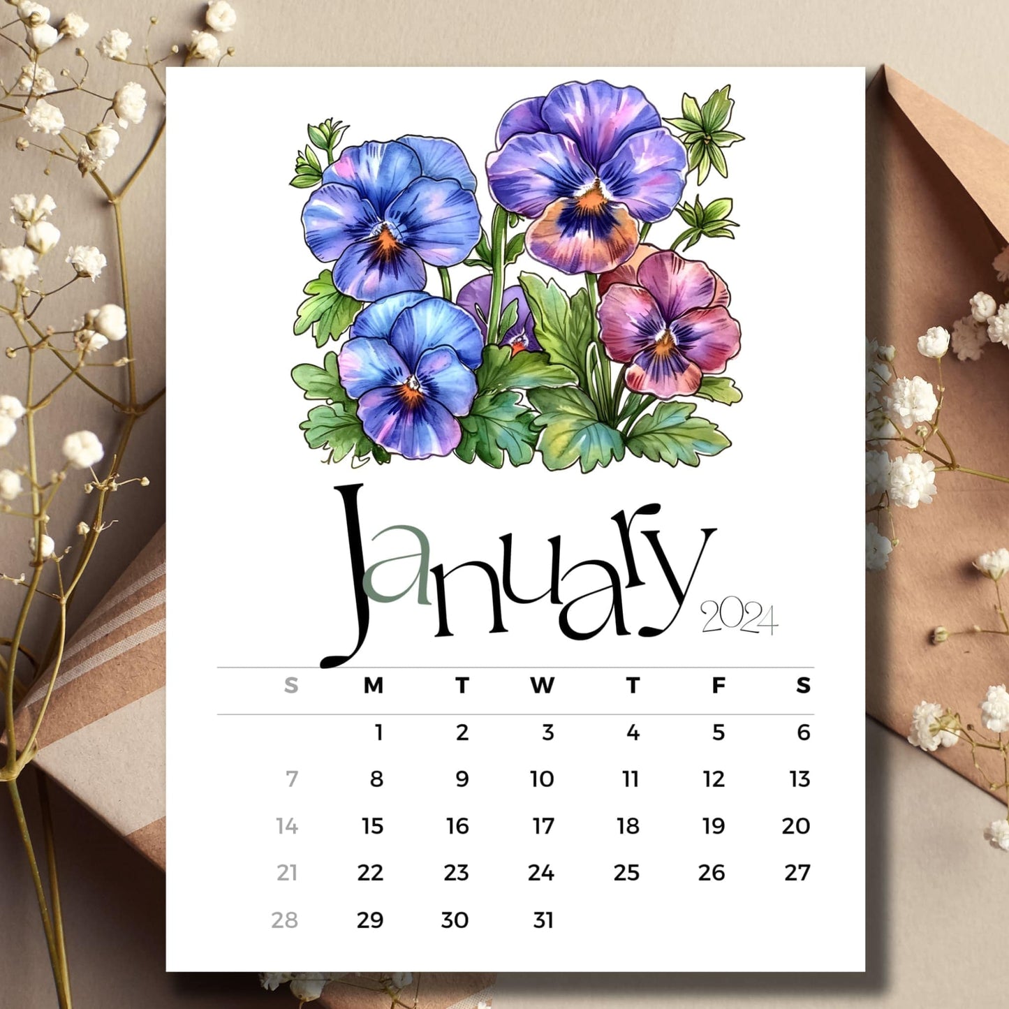 Pansy palette floral January 2024 full year calendar on a table with envelope and small white flowers.