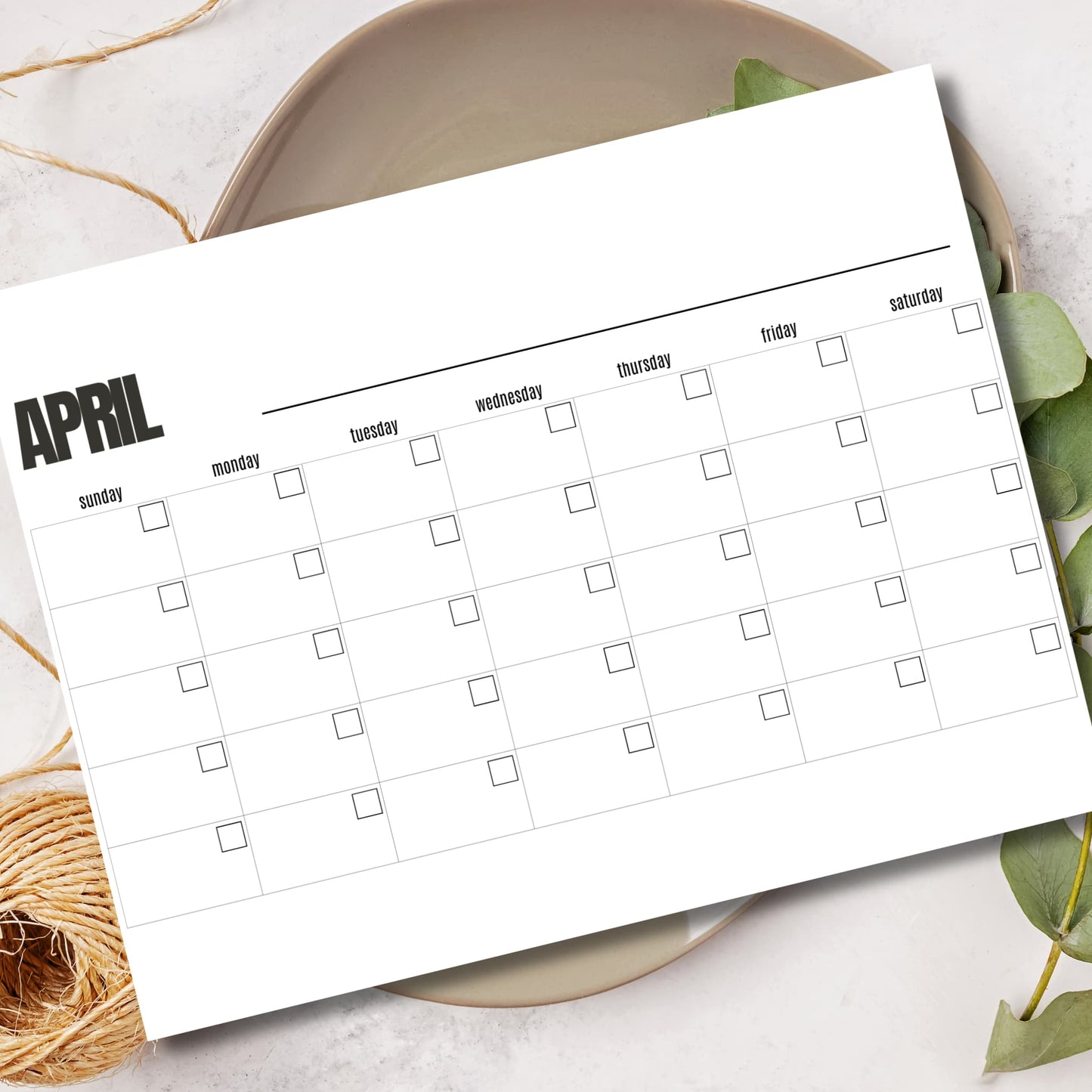 Printable April planner PDF A4 size monthly event organizer displayed in ceramic bowl with green leaves