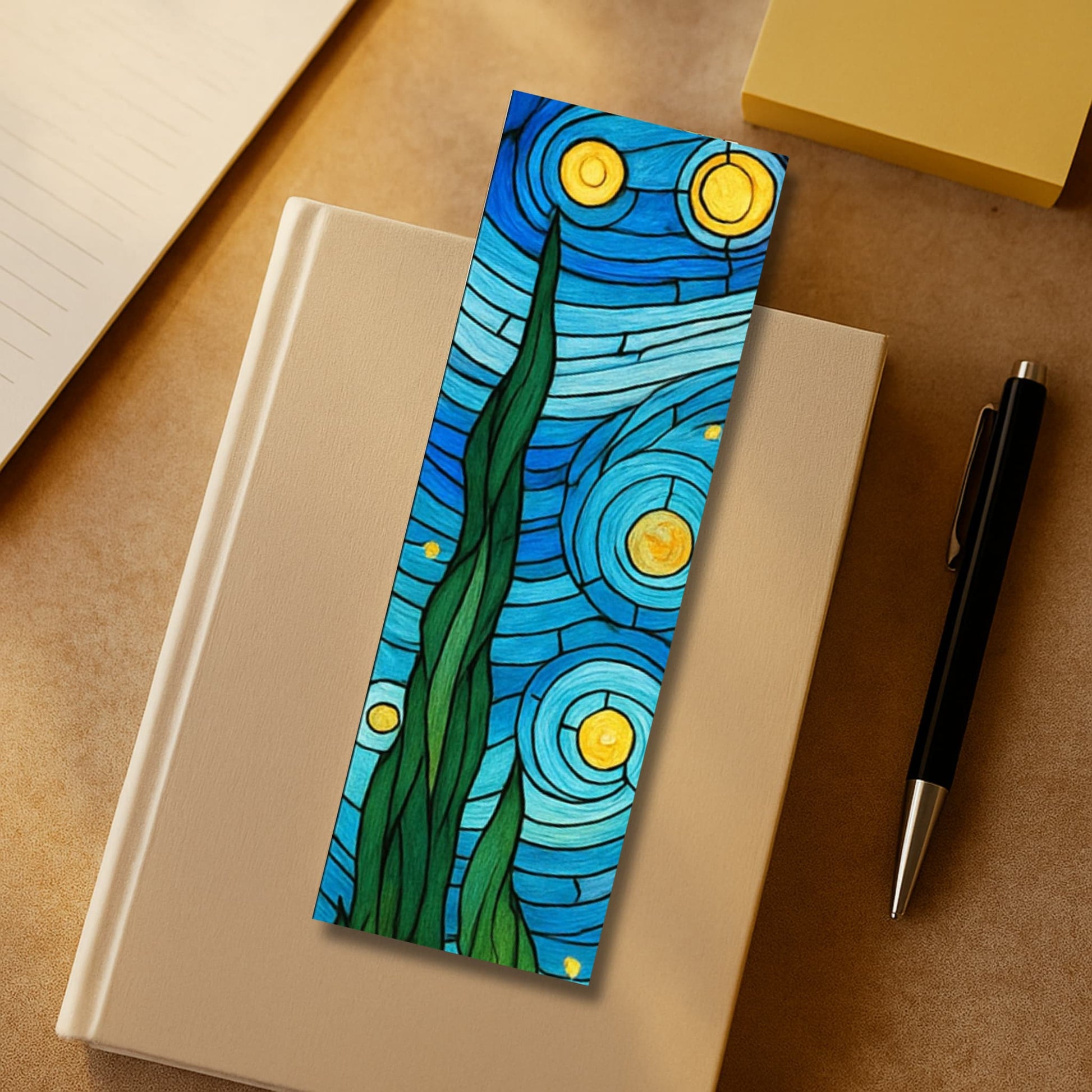 Starry night cypress tree stained glass bookmark with swirling blue sky and golden stars on beige notebook