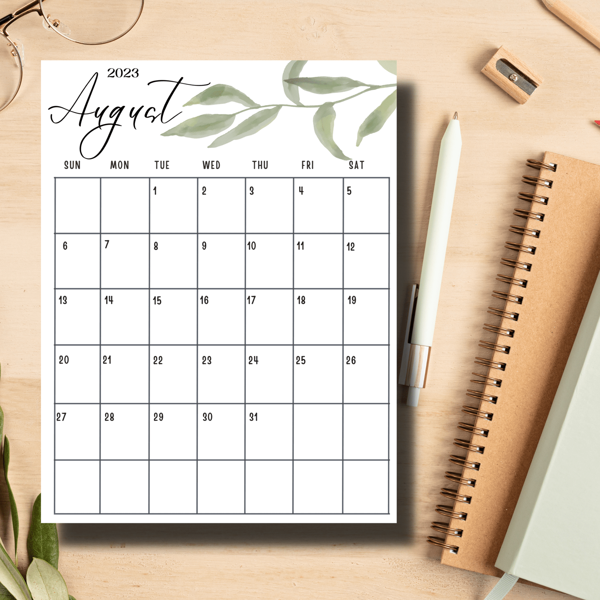 august 2023 printed calendar sheet with notebooks and pen on a table