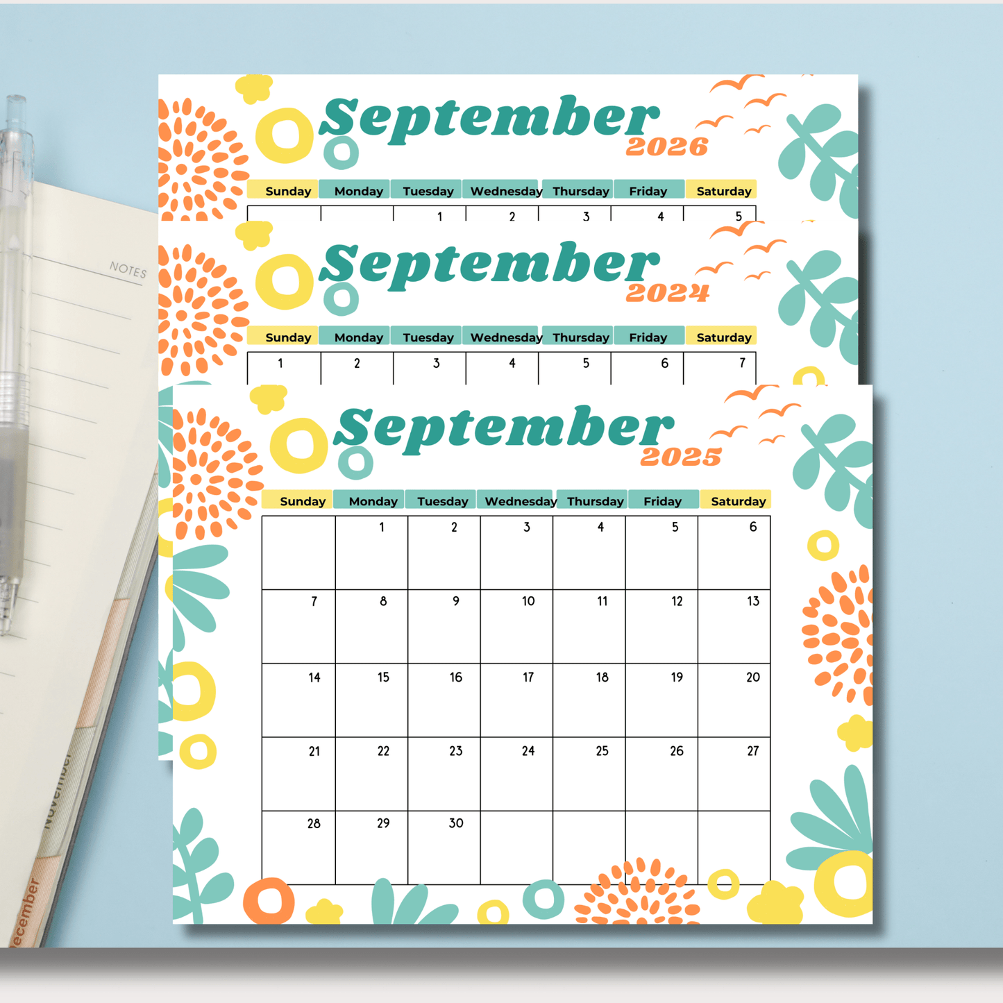 September calendars for 2024-2026 with vibrant floral design. Shown with notebook and pen on light blue background, emphasizing organization."