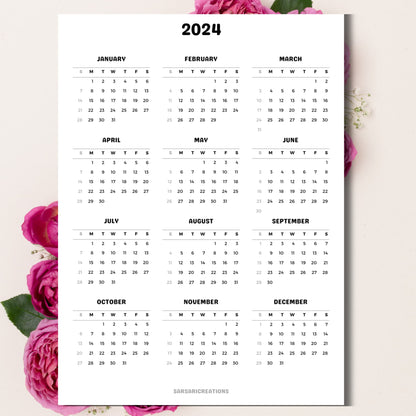 2024 calendar page on a beige background with pink peonies behind the paper.
