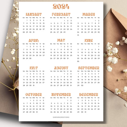 2024 yearly calendar in professional style on a table with an envelope and small white flowers in the background.