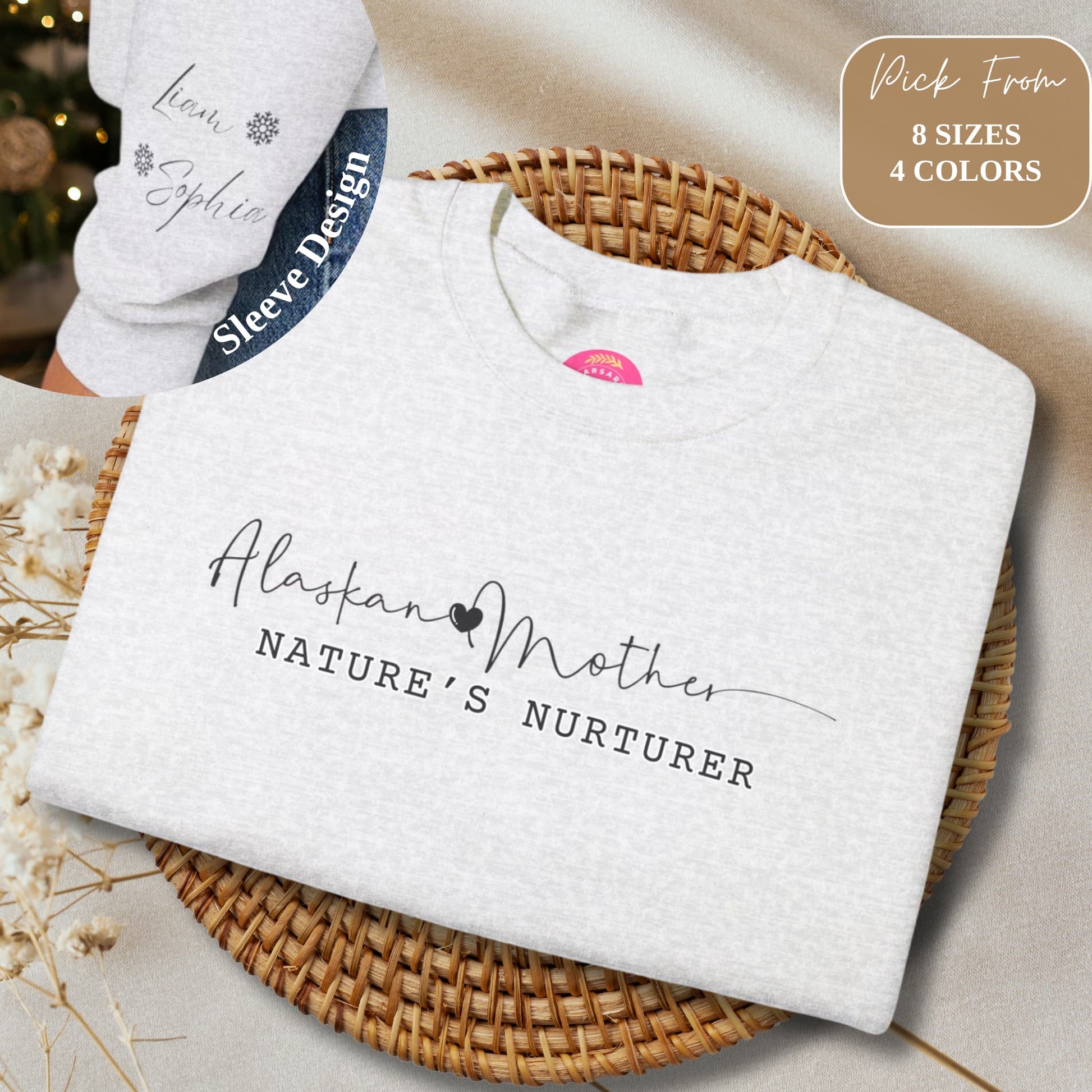 Folded Alaskan Mother Personalized Crewneck Sweatshirt on a beige background, featuring sleeve design with kids' names and snowflake detail.