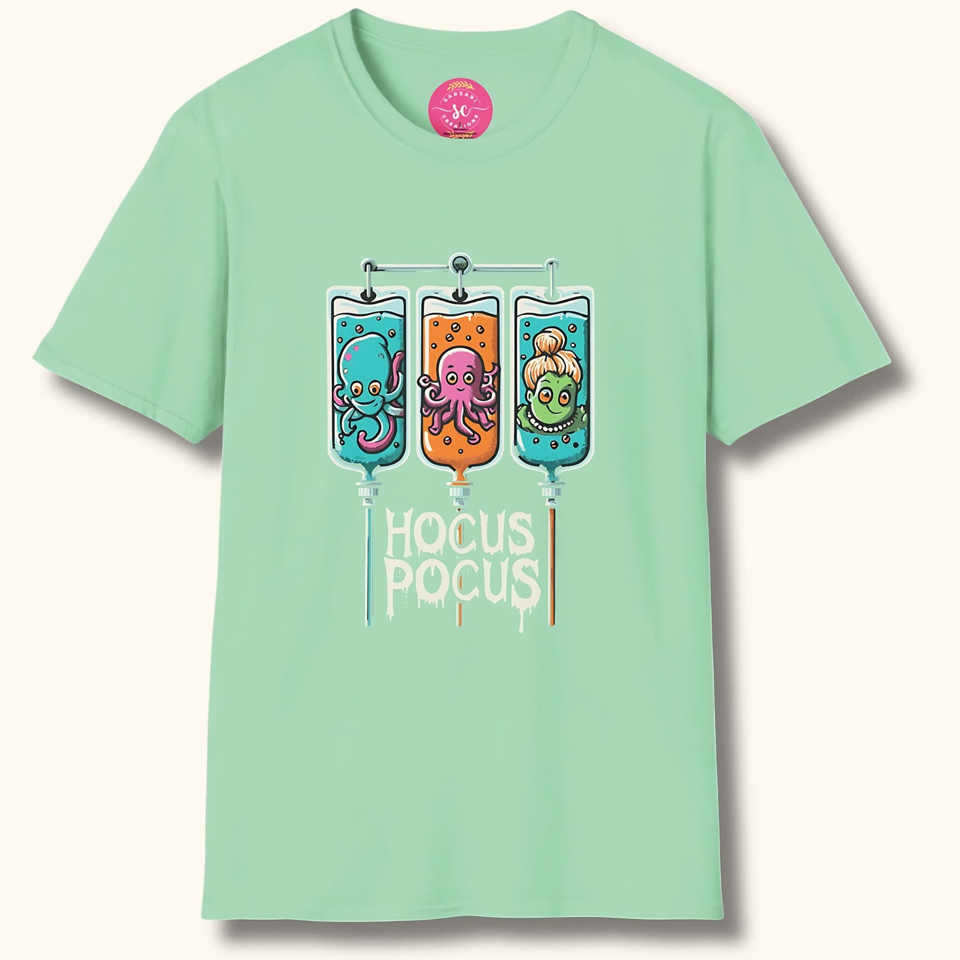 Mint green t-shirt with 'Hocus Pocus' design. Three IV bags contain cute octopus, squid, and mermaid characters. Sarsari Creations label visible.