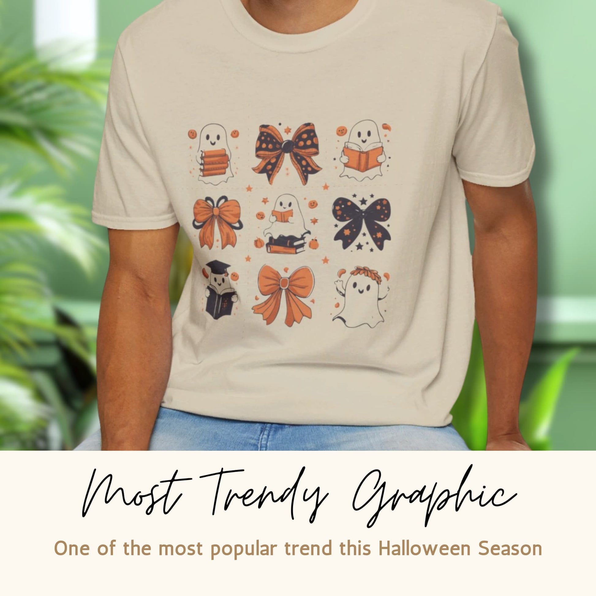 Sand-colored t-shirt with Halloween design featuring cute ghosts, bows, and books. Labeled 'Most Trendy Graphic' for Halloween season.