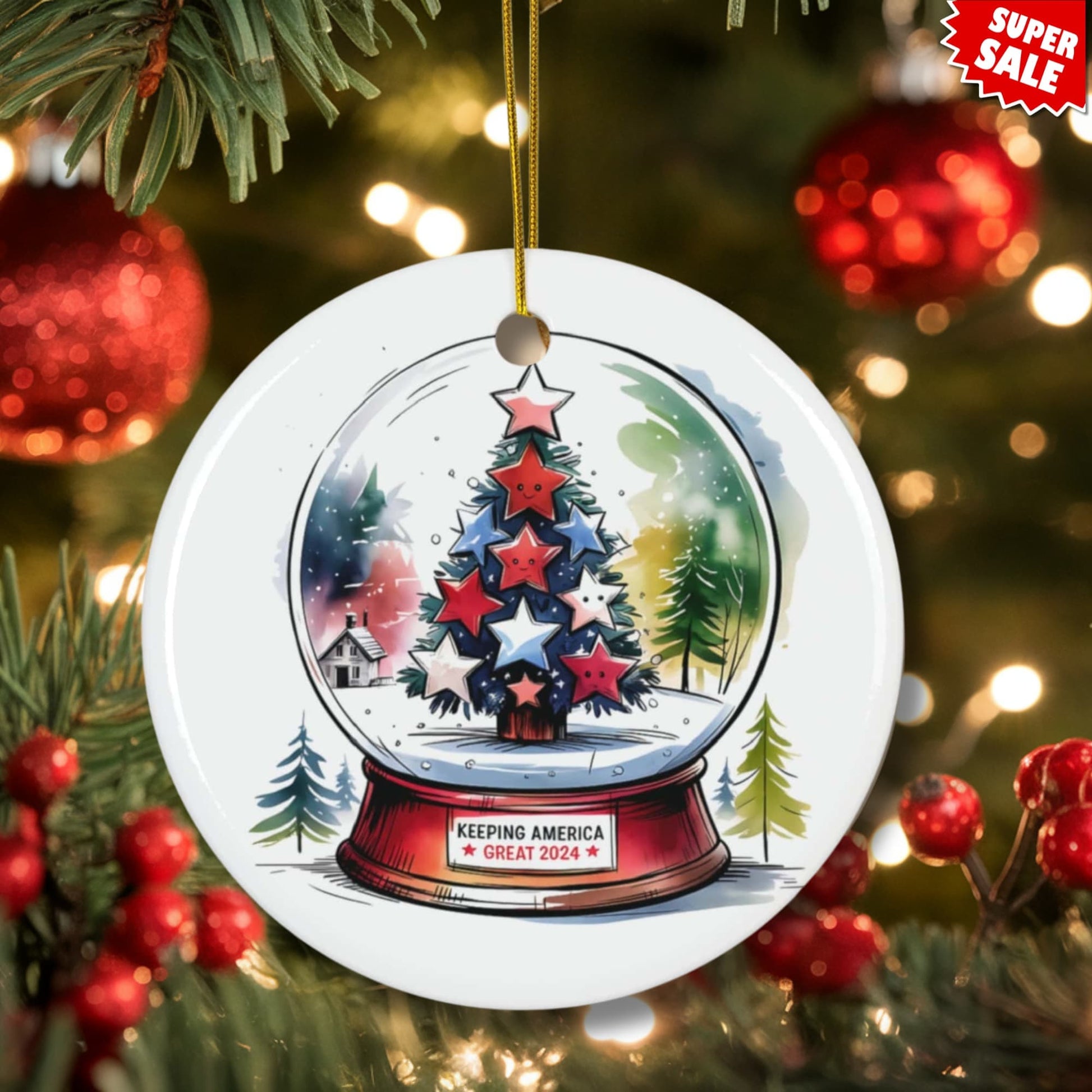 Circle shaped ceramic ornament featuring winter snowglobe design with red, white and blue star-decorated tree. White porcelain finish with detailed snowy scene on rustic wooden background.