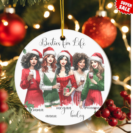 Holiday lifestyle photo of Besties for Life personalized ornament hanging on Christmas tree with red berries, ornaments, and warm lighting, featuring five friends in coordinated red and green holiday outfits