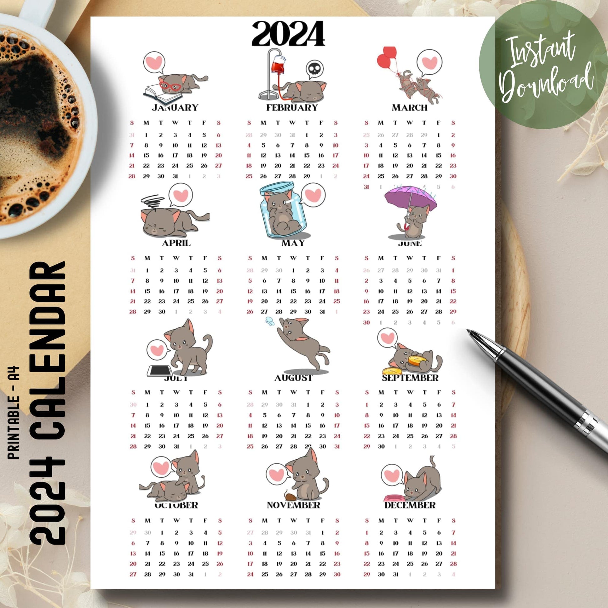 Cute cat illustrated 2024 full year calendar on brown desk with coffee cup on left and pen on right.