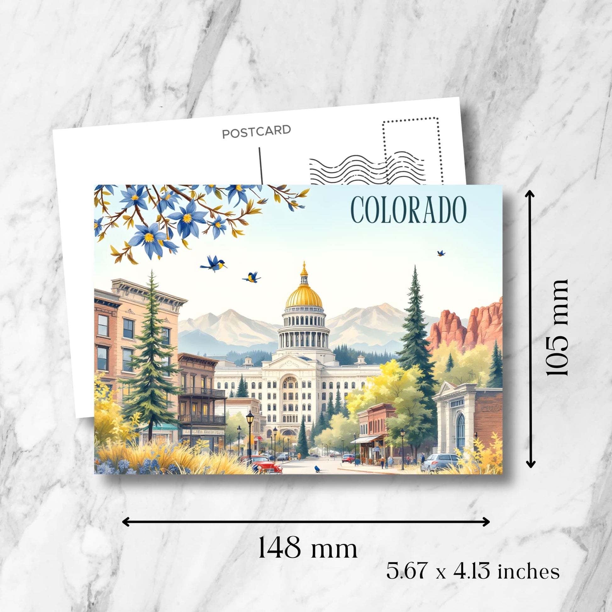 Colorado State Capitol postcard showing 148x105mm dimensions, featuring downtown Denver scene with Victorian architecture, mountain vista, columbine flowers, and bluebirds with postcard formatting