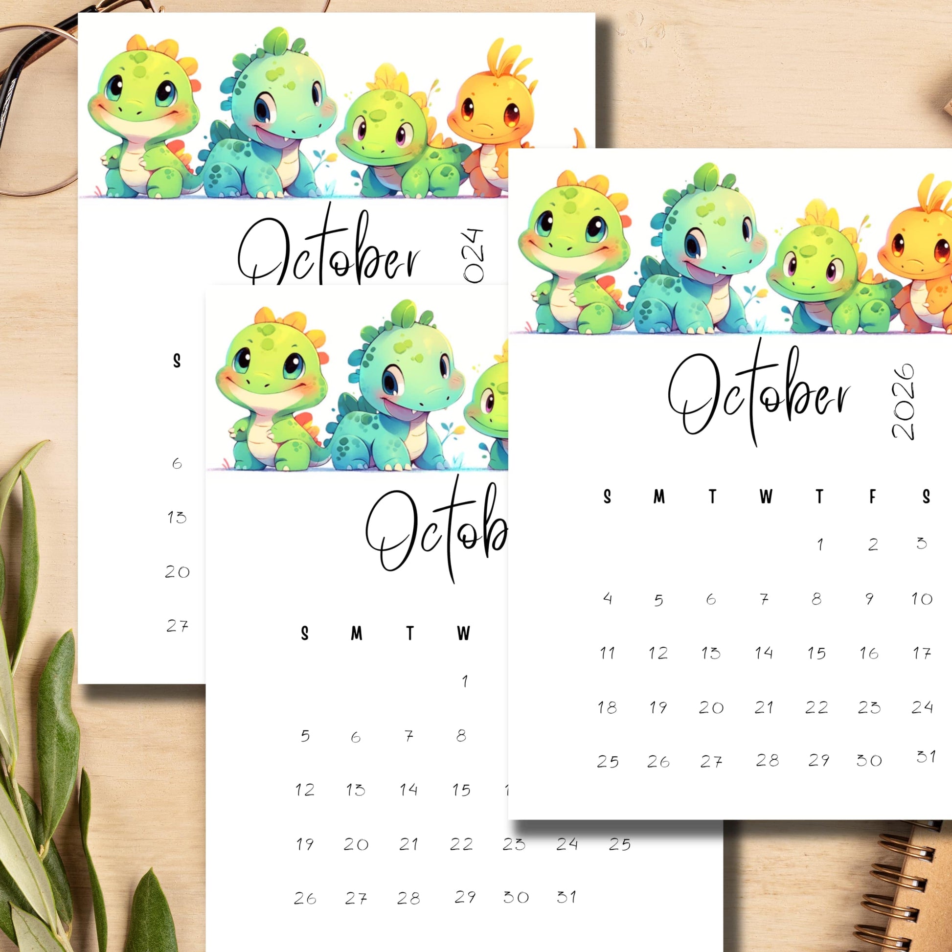 esktop scene with October 2024-2026 monthly calendars featuring colorful baby dinosaurs, displayed with glasses and plant, emphasizing the A4 size and vertical layout.