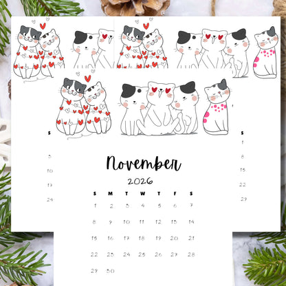 Vertical November 2025 calendar with sweet cat illustrations and green plant styling. Features black and white cats with red heart details and minimalist date grid on wooden background.