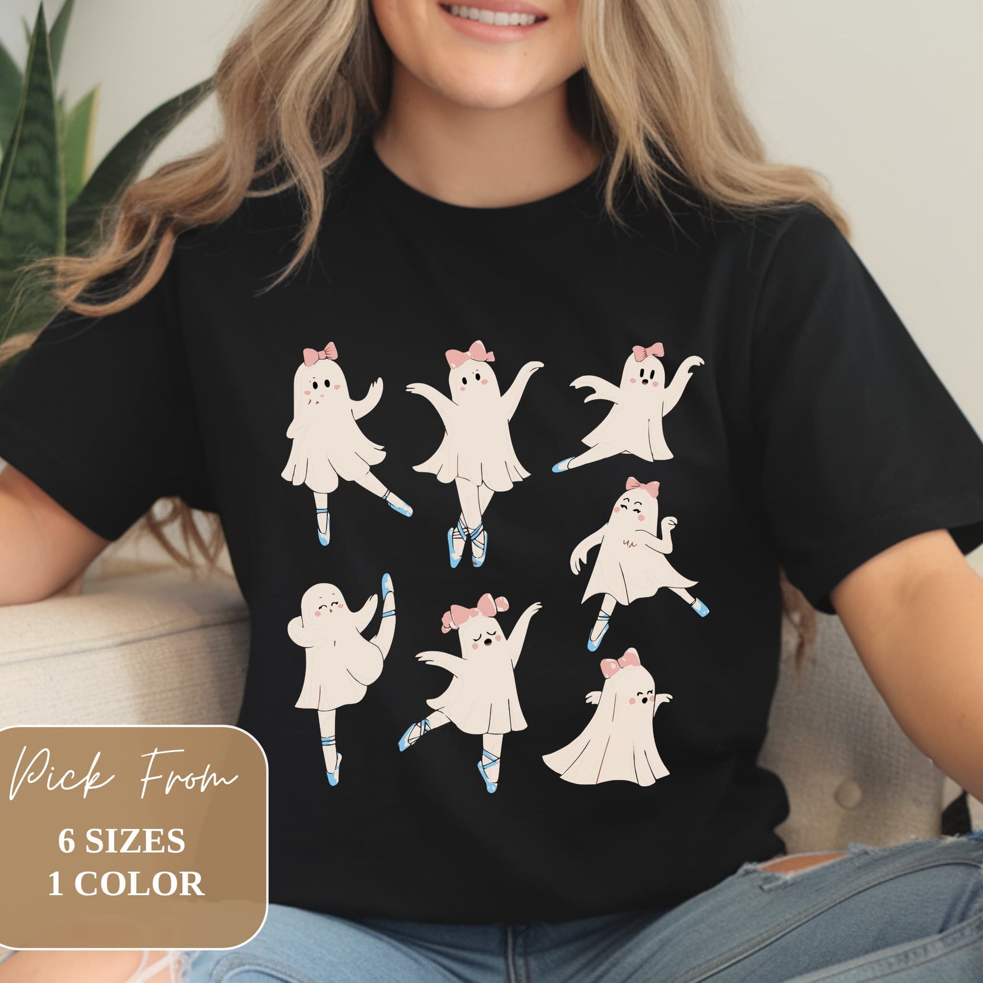 Black t-shirt featuring seven cartoon ghost ballerinas in various dance poses. Ghosts wear pink bows and blue ballet slippers. Modeled on person wearing jeans. Text overlay indicates 6 sizes available in 1 color.