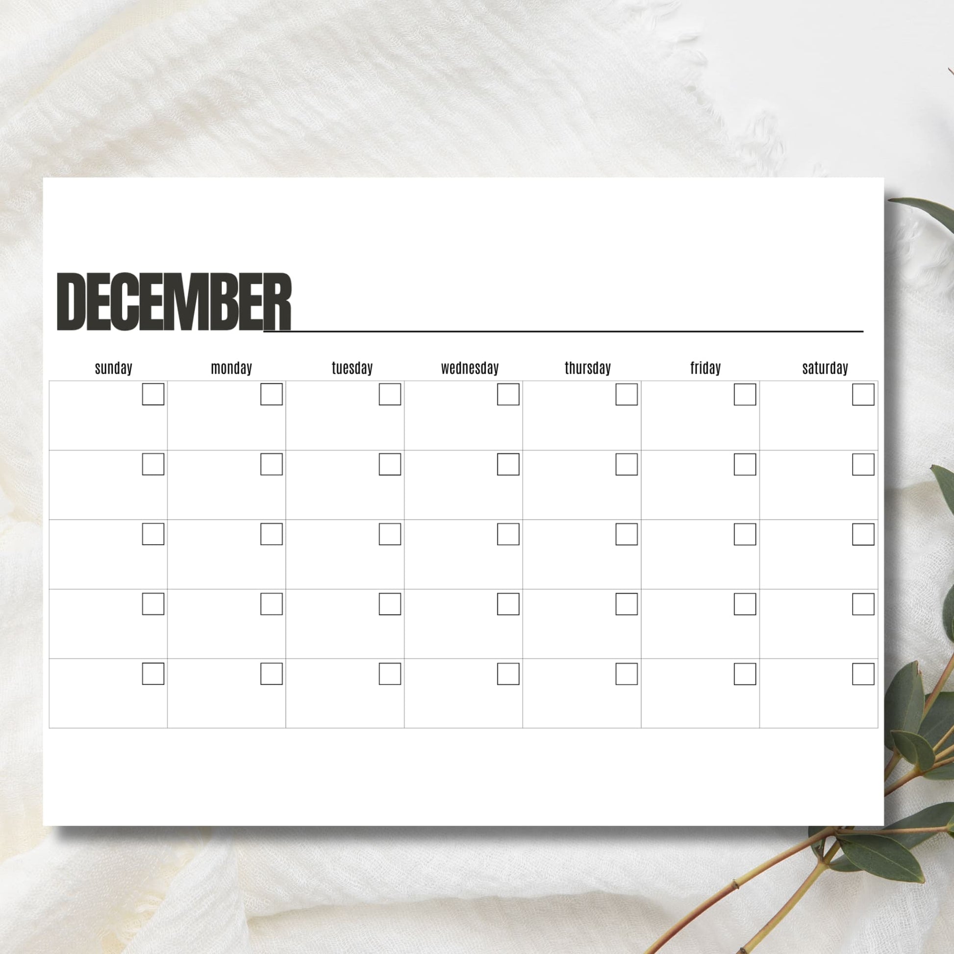 Clean December monthly organizer on marble background showing horizontal holiday layout