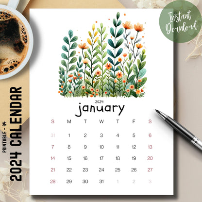 Evergreen Embrace 2024-25 full year calendar on a brown desk with a coffee cup on the left and pen on the right.