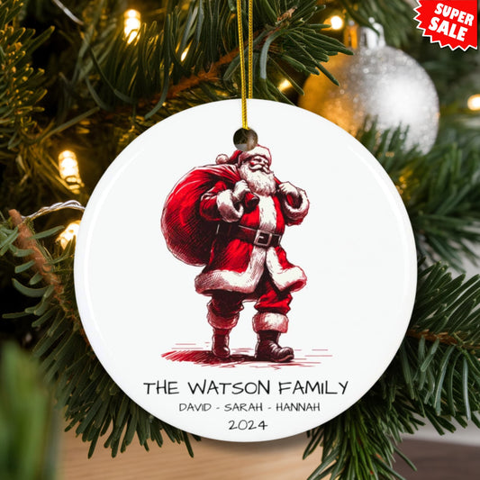 Watson family ceramic ornament displayed on lit Christmas tree with silver baubles, featuring gift-bearing Santa design and Super Sale tag