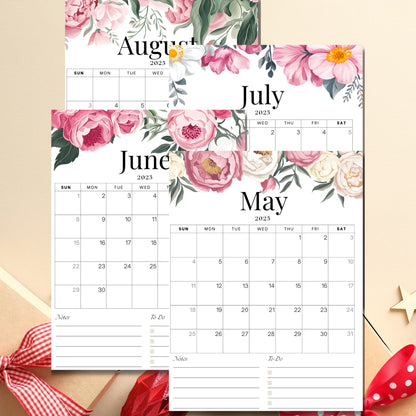 Summer months of 2025 calendar displaying May through August, decorated with vintage pink roses and white peonies, including notes section, shown with seasonal red ribbon accent