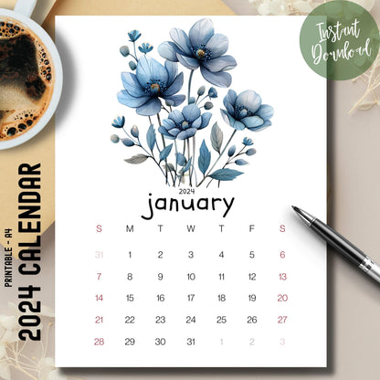 Frosty Flora January 2024-25 full year planner on a brown desk with a coffee cup on the left and a pen on the right.