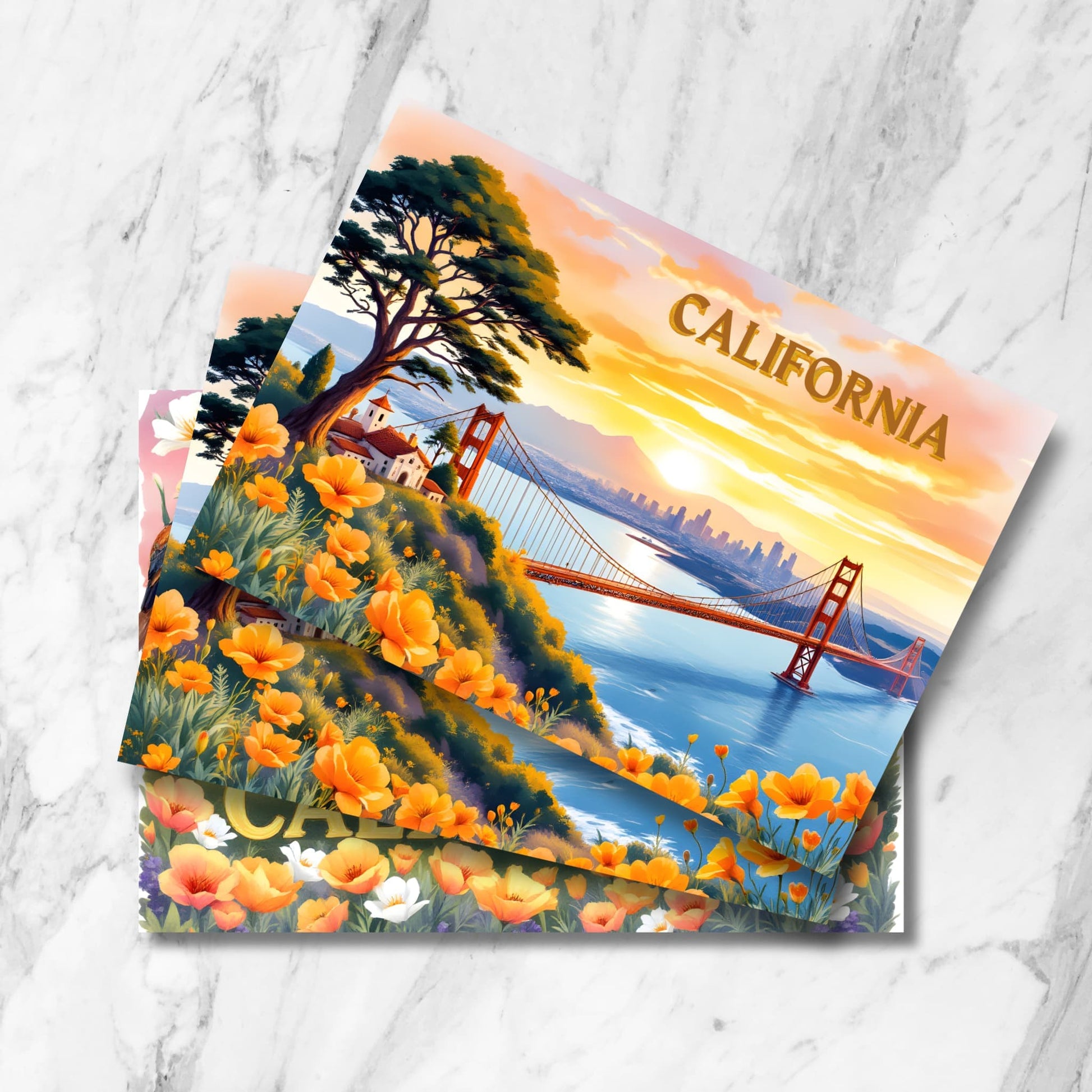 Vintage-style California postcards featuring Golden Gate Bridge at sunset, San Francisco skyline, Spanish mission architecture, cypress tree, and orange poppies in foreground, shown as stacked prints on marble background