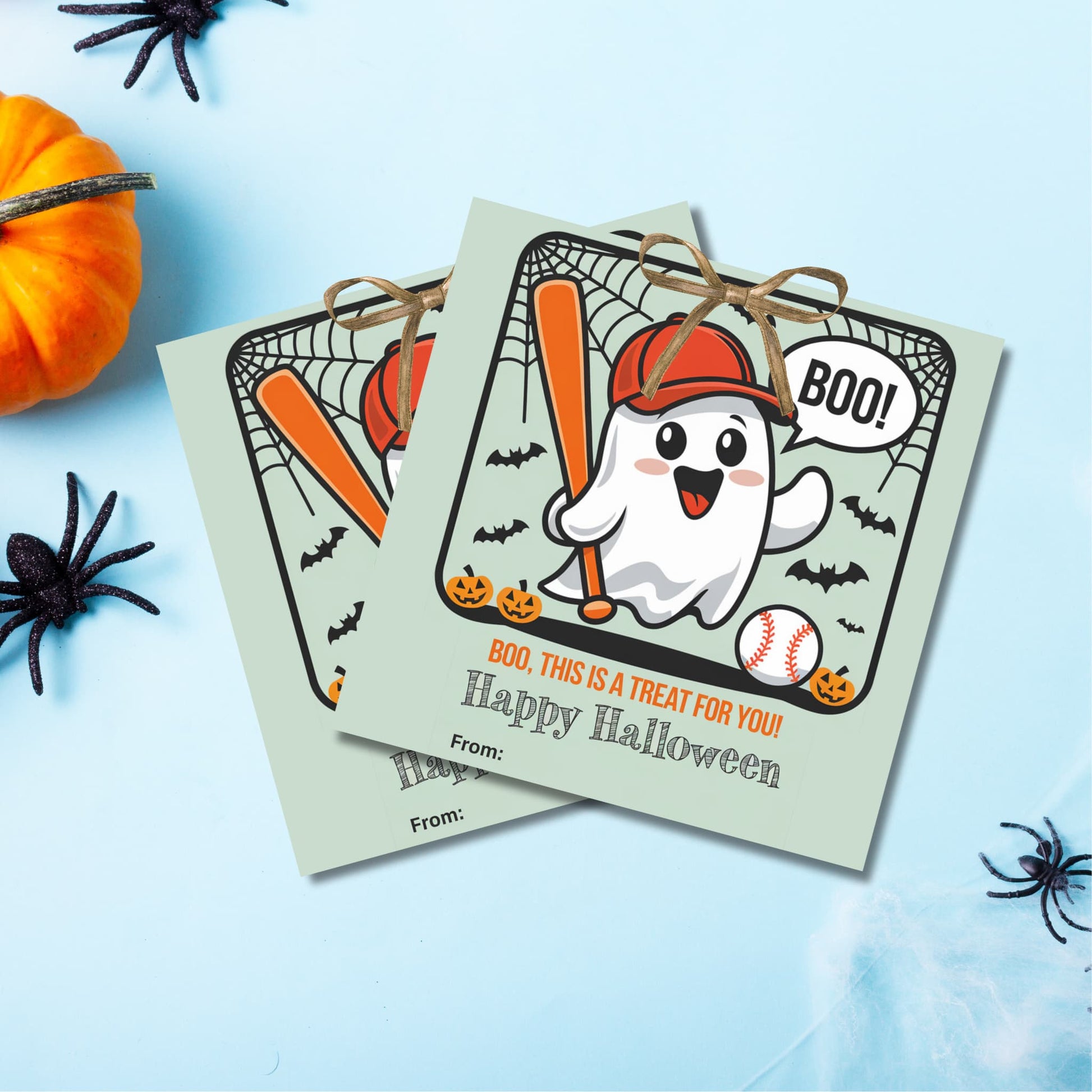 Green Halloween favor tags with cute baseball ghost design, displayed with pumpkin and spider decorations for costume parties