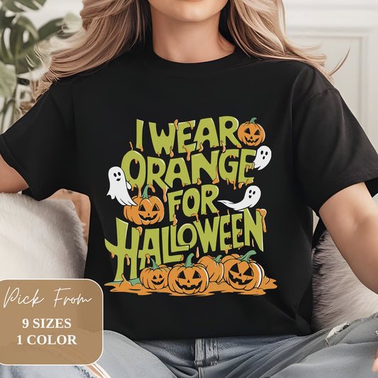 Black t-shirt with 'I WEAR ORANGE FOR HALLOWEEN' in retro-style green and orange lettering. Design features cartoon jack-o'-lanterns and ghosts. Modeled on person wearing jeans. Text overlay indicates 9 sizes available in 1 color.