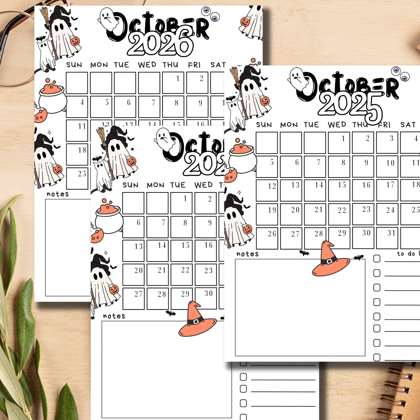 Desktop scene with October 2024-2026 monthly calendars featuring black and white Halloween doodles with orange accents, displayed with office supplies, emphasizing the A4 size and notes section perfect for student organization.