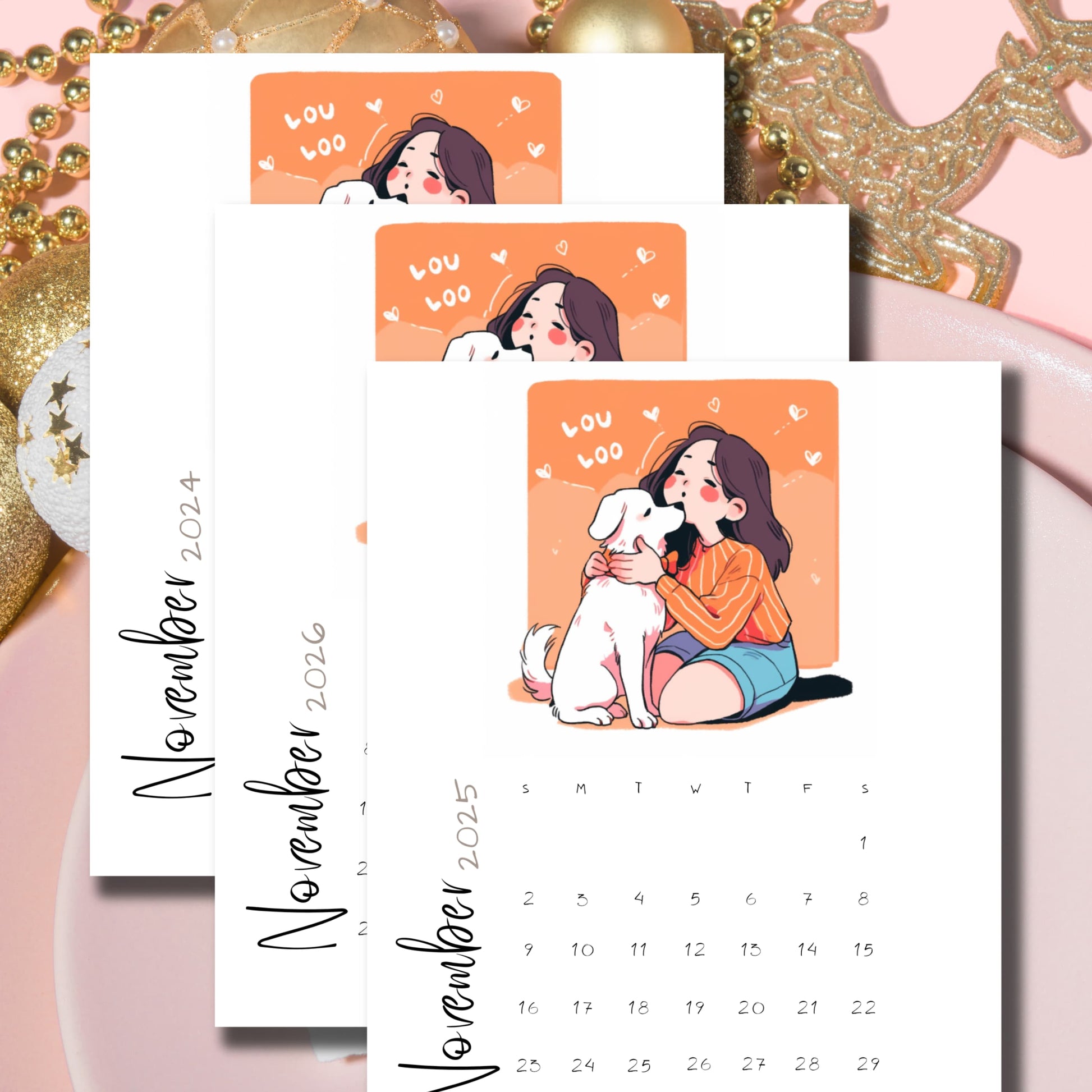 Layered November calendars with sweet girl and puppy artwork, floating hearts design in coral orange, displayed with golden holiday decorations