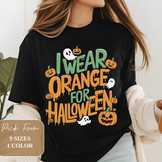 Black t-shirt with colorful text 'I WEAR ORANGE FOR HALLOWEEN' in green and orange. Design features cartoon ghosts and jack-o'-lanterns. Modeled on person wearing cream cardigan. Overlay indicates 9 sizes available in 1 color.