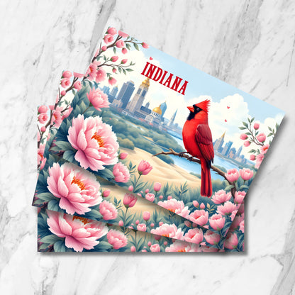 Indiana state symbols postcard featuring northern cardinal perched with Indianapolis skyline backdrop. Pink peonies frame detailed city view with golden-domed statehouse. Watercolor-style illustration with romantic sunset lighting.