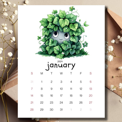 Ivy Intrigue January 2024 full year calendar on a table with envelope and small white flowers.