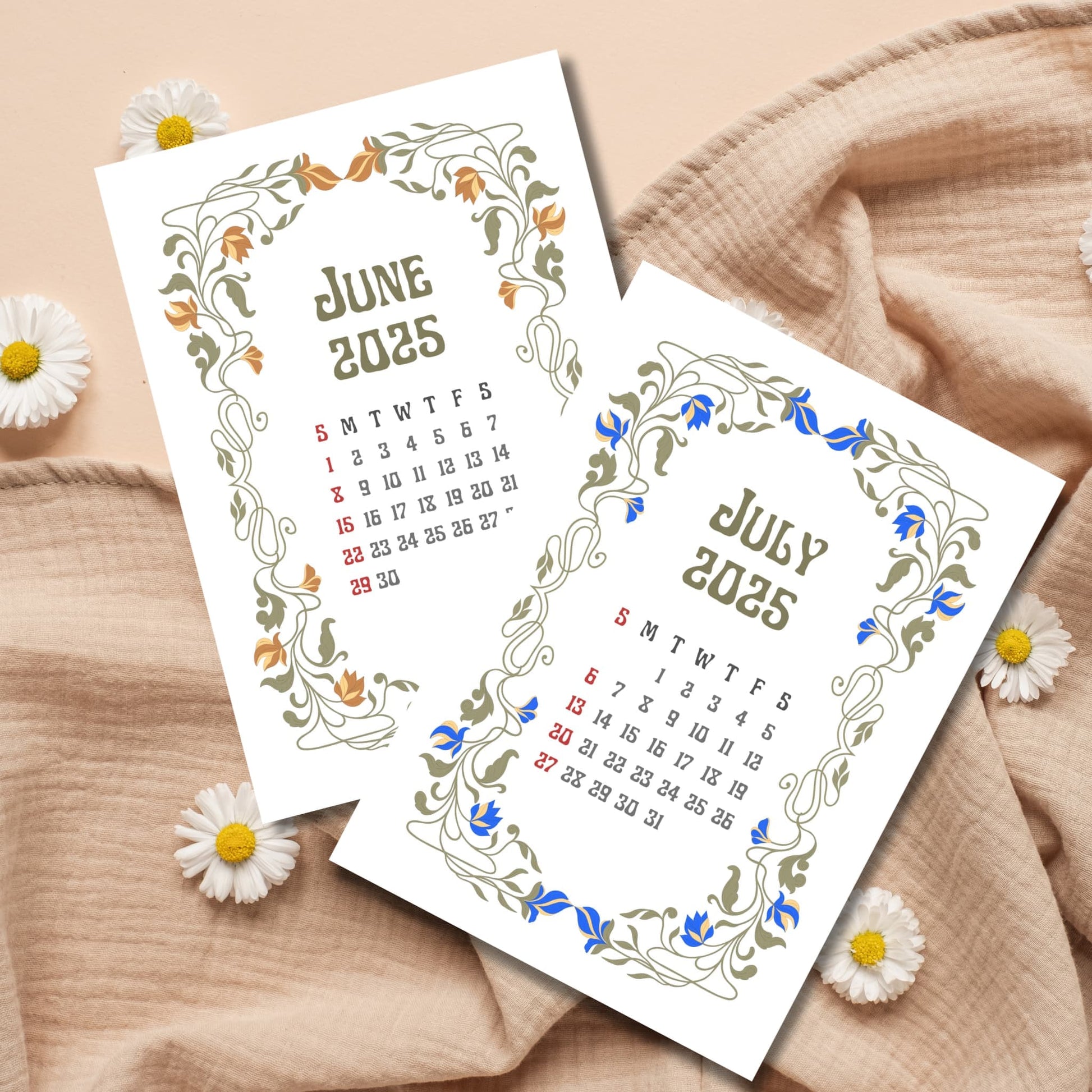 June and July 2025 calendar sheets with elegant Art Nouveau floral frames in orange and blue, displayed with fresh daisies and natural linen fabric