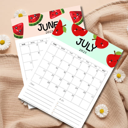 June 2025 calendar featuring watermelon slice characters and July 2025 calendar with apple illustrations, displayed against a neutral beige fabric with daisy flowers. Monthly planner includes Sunday start grid layout with notes section.