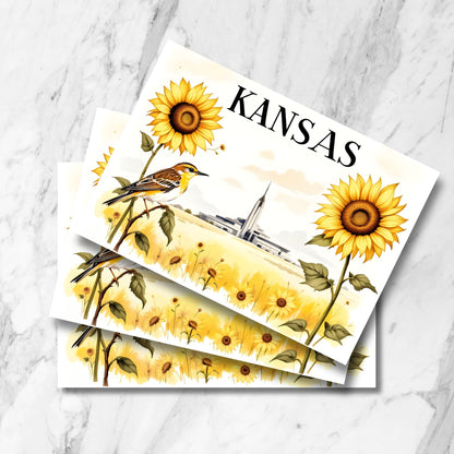 Stack of Kansas postcards featuring watercolor illustration of Kansas City Temple amid sunflower field with meadowlark, displayed on marble background