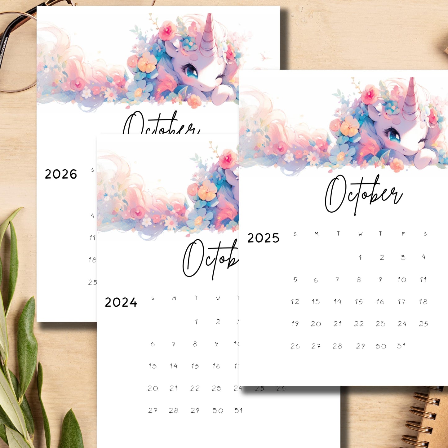 Desktop scene with October 2024-2026 monthly calendars featuring whimsical unicorn illustrations, displayed with office supplies, emphasizing the vertical layout and A4 size perfect for educational settings.