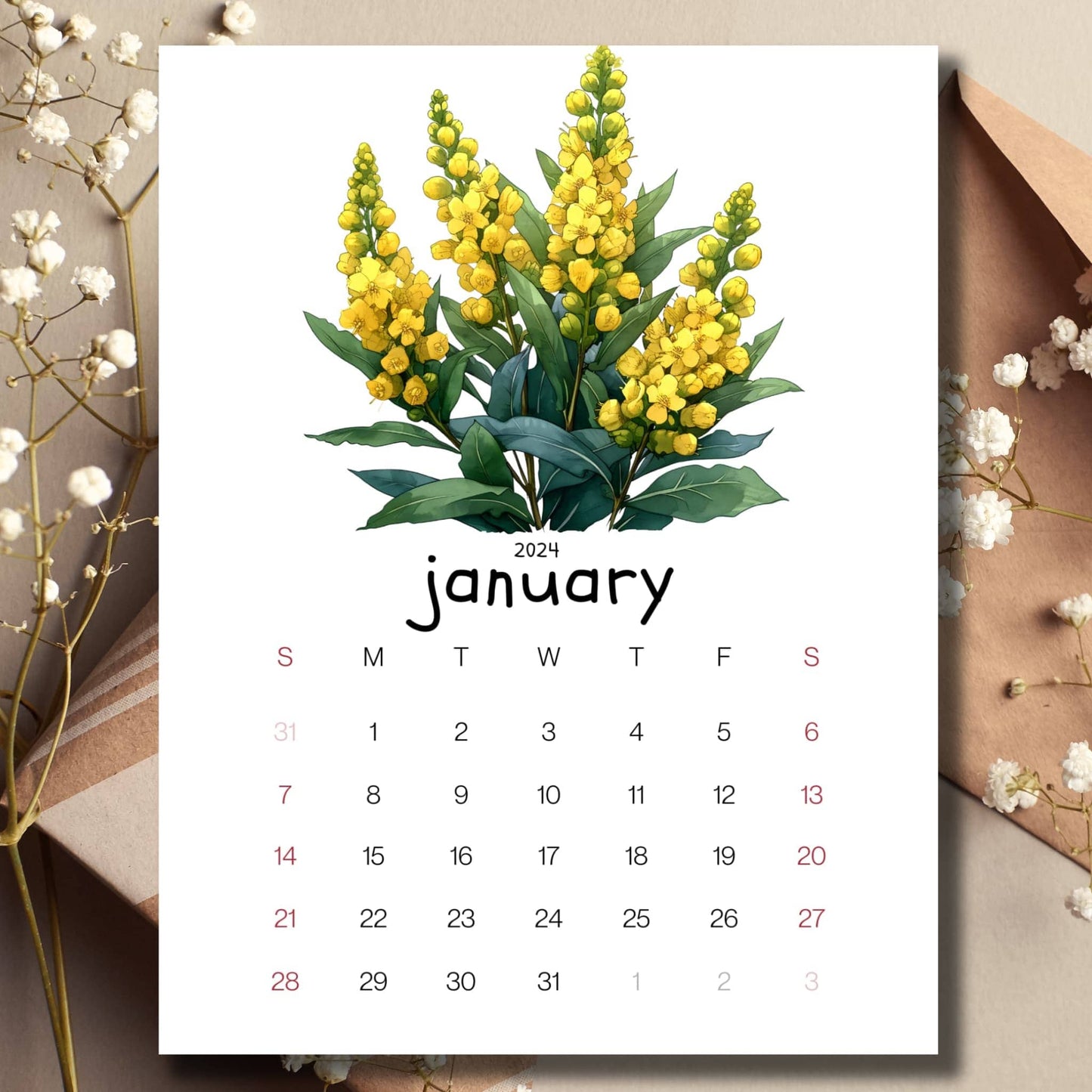 Mahonia Magic January 2024 full year calendar on a table with an envelope and small white flowers in the background.