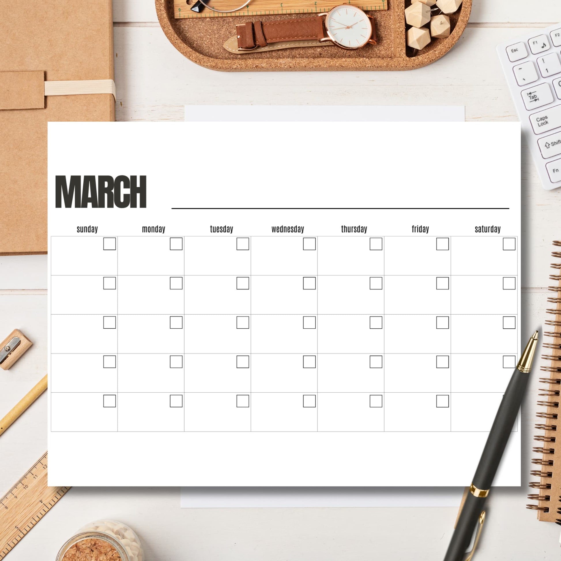 March calendar template on white office desk with cork organizer tray and gold pen for spring planning