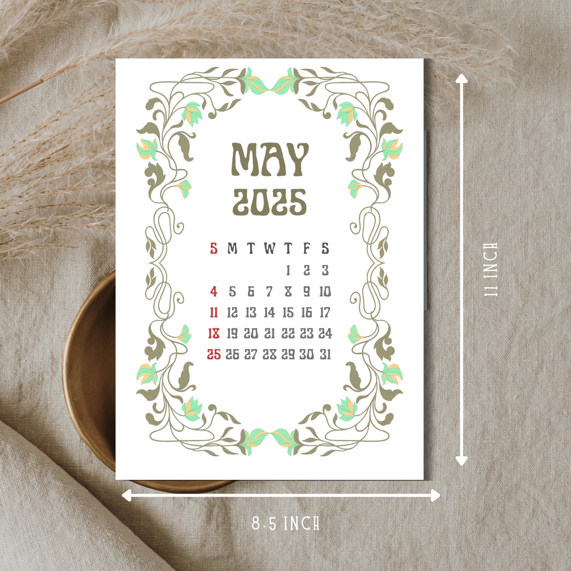 May 2025 calendar page with mint green floral Art Nouveau border, showing 8.5 x 11 inch dimensions, displayed on neutral linen background with wooden bowl