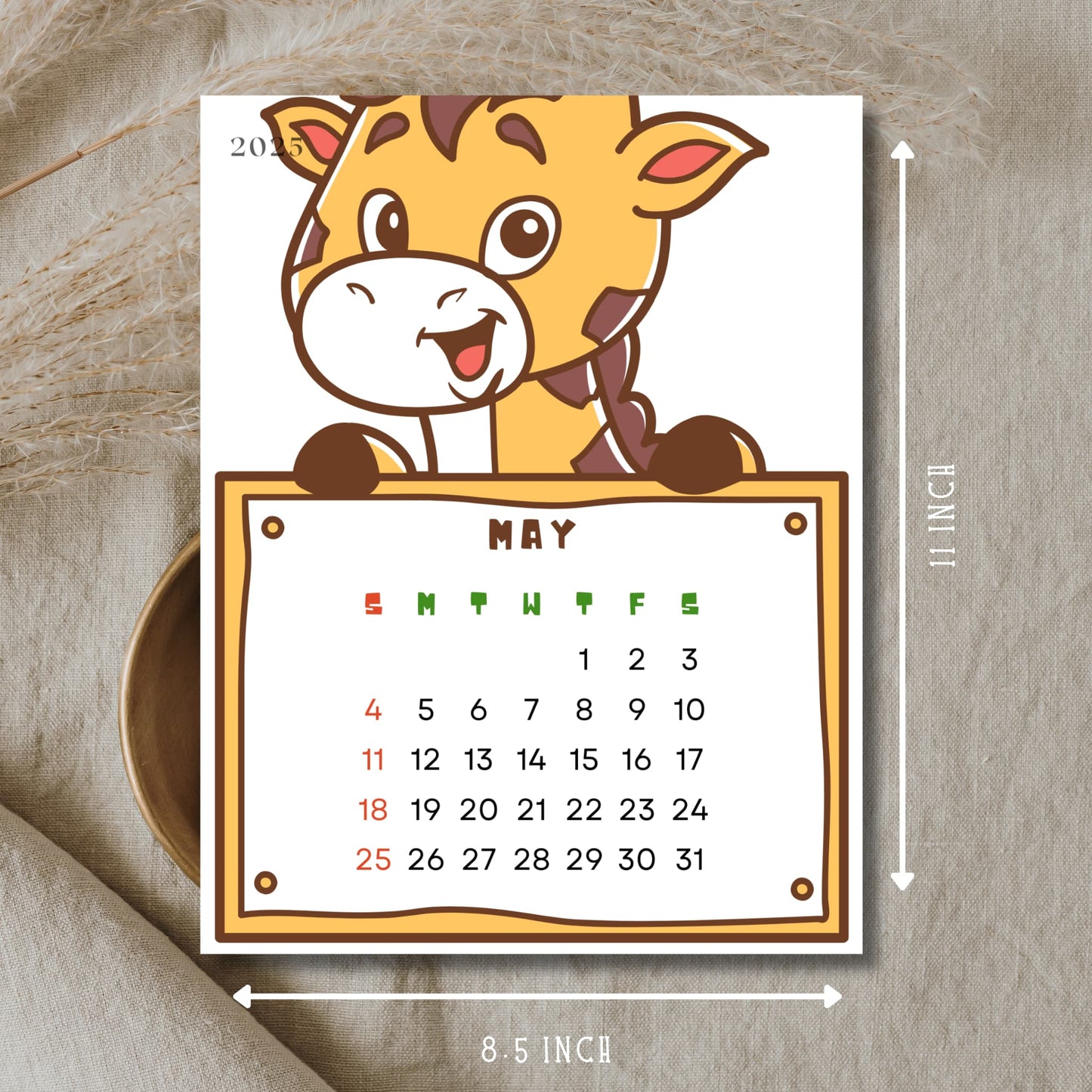 May 2025 calendar with cartoon giraffe holding monthly grid. Features Sunday start layout with dates 1-31, shows 8.5x11 inch dimensions, displayed on natural linen background.