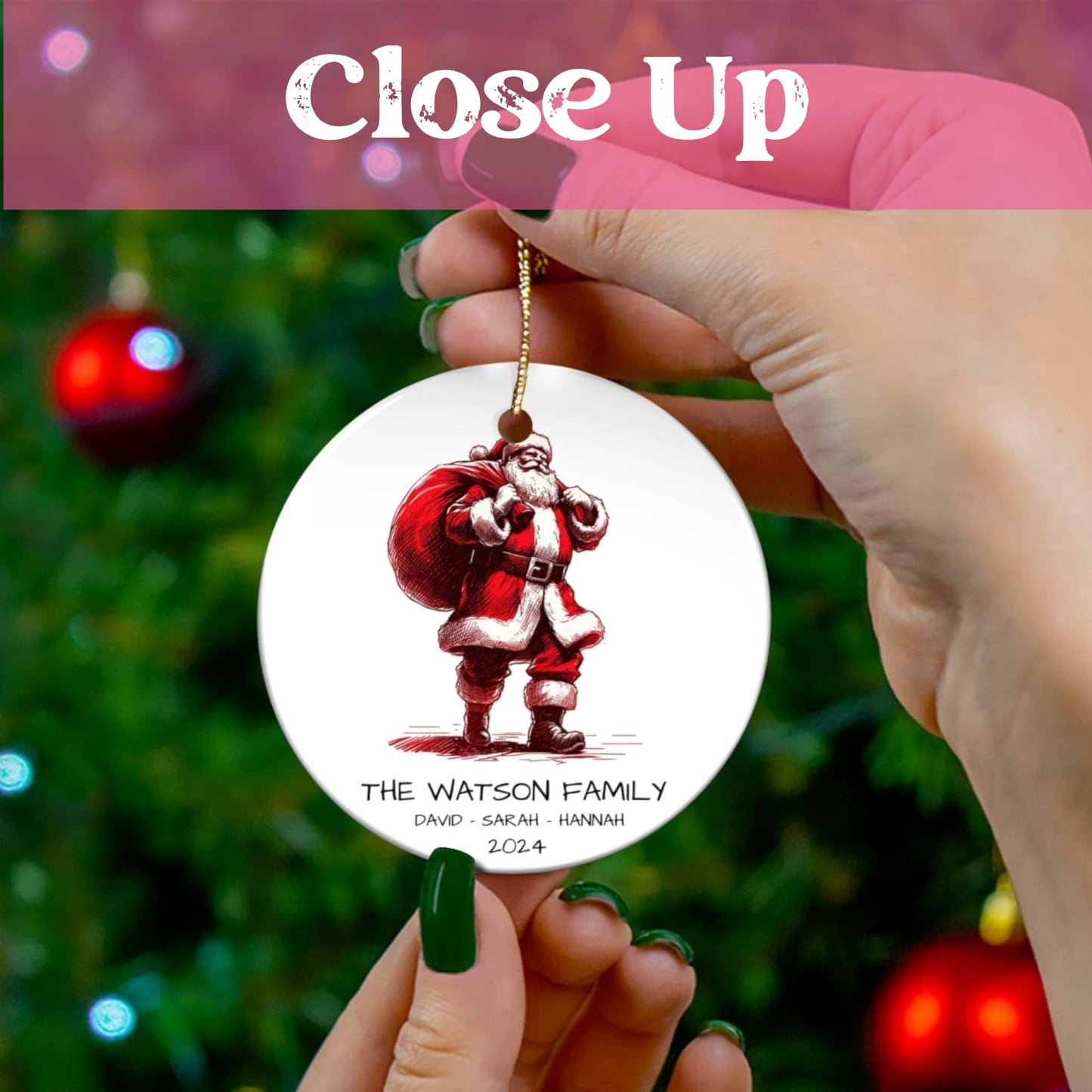 Close-up of personalized ceramic ornament showing Santa with gift bag design and family names against Christmas tree backdrop