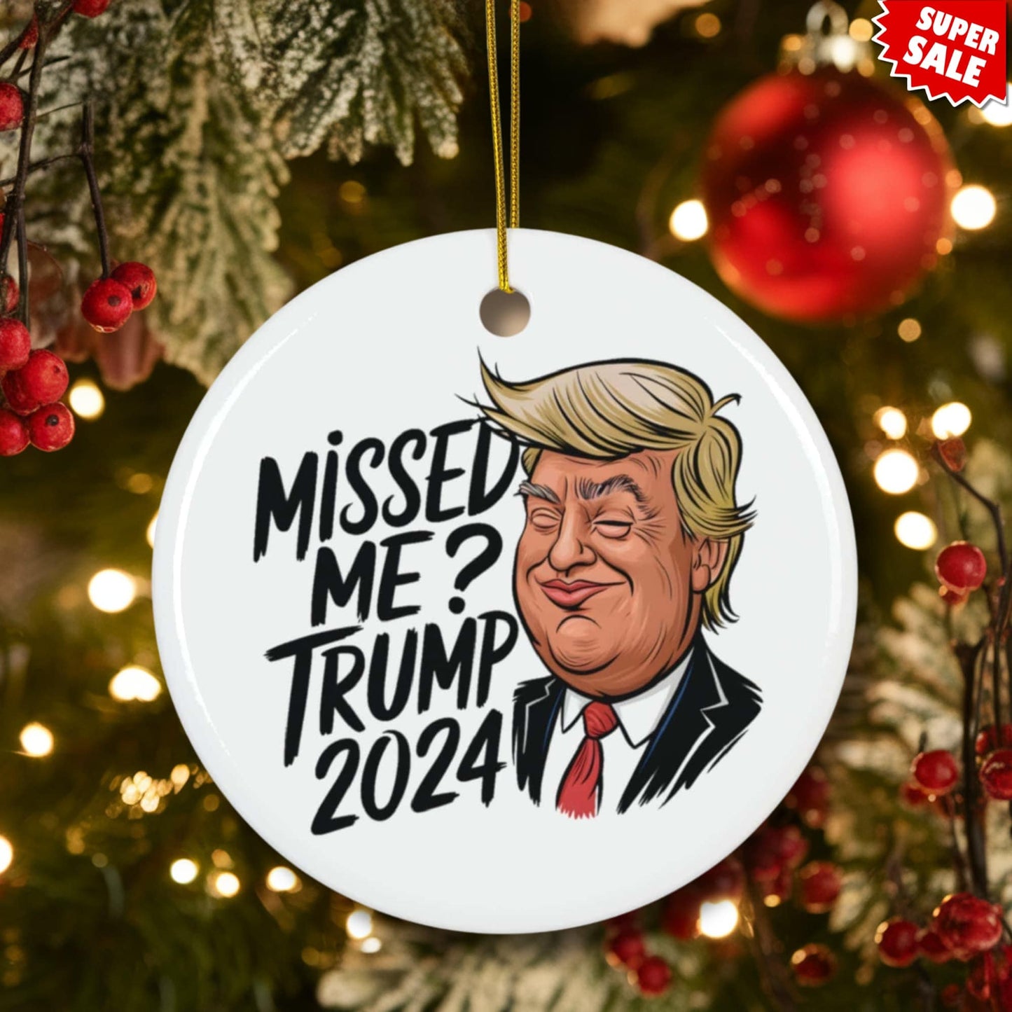 White ceramic circle ornament with humorous political message and cartoon portrait, displayed on Christmas tree with red berries and warm holiday lights.