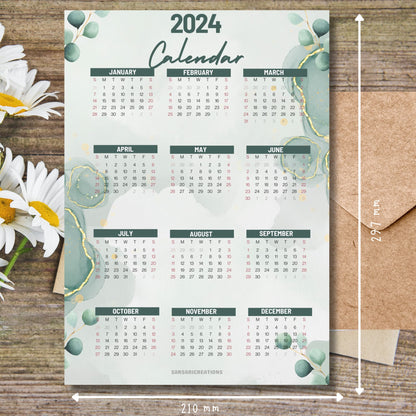 Modern aesthetic 2024 calendar on brown wooden desk with white flowers and size guide.