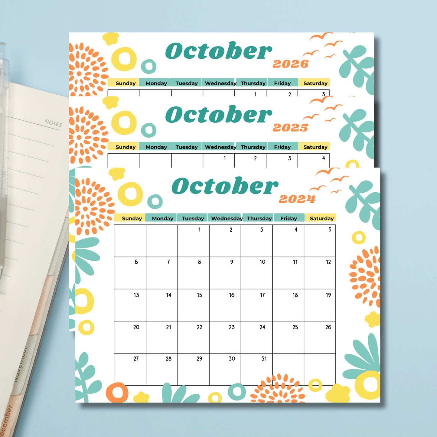 Colorful October 2024-2026 calendars with modern floral illustrations, displayed with a notebook and pencil.