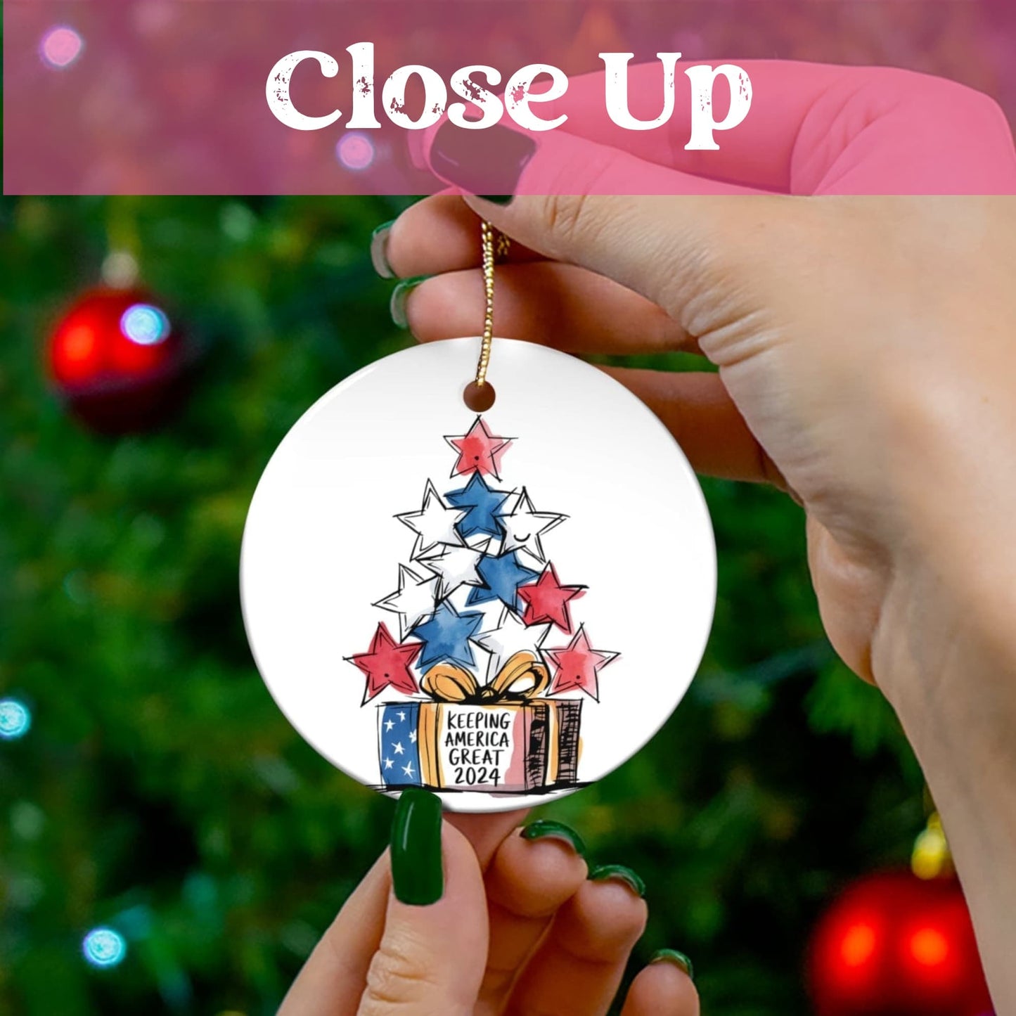 Close-up view of patriotic ceramic ornament showing detailed star tree design in American colors, held against festive Christmas tree background with holiday lights.